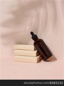 Brown glass bottle with a pipette for cosmetics, oils, serum on a beige background with wooden steps. Shadow from a palm leaf on the background