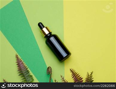 brown glass bottle with a pipette on a green background. Template for cosmetic liquid products, advertising and promotion