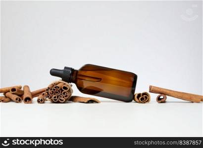 Brown glass bottle with a pipette on gray background. Containers for cosmetics, oils, serums