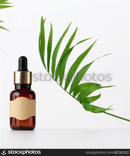 Brown glass bottle with a pipette stands on a brown background. Container for cosmetics, serum and oil