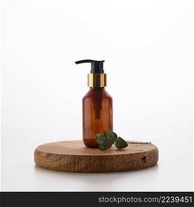 Brown glass bottle with black pump of cosmetic products on white table. Natural organic spa cosmetic, beauty concept. Mockup