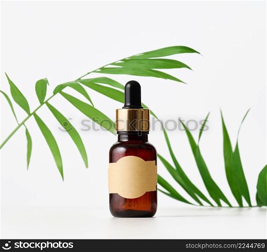 brown glass bottle with paper empty label and pipette. Cosmetic packaging, advertising and promotion