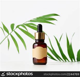 brown glass bottle with paper empty label and pipette. Cosmetic packaging, advertising and promotion