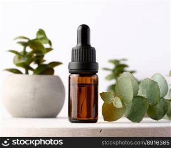Brown glass bottle with pipette for cosmetic procedures on a wooden background