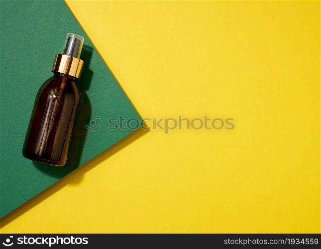 brown glass bottle with spray on yellow green background, top view. Cosmetics SPA branding mockup