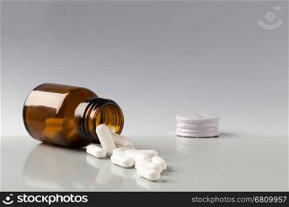 Brown glass pill bottle and white pills