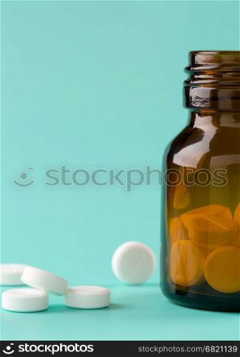 Brown glass pills bottle and round pills