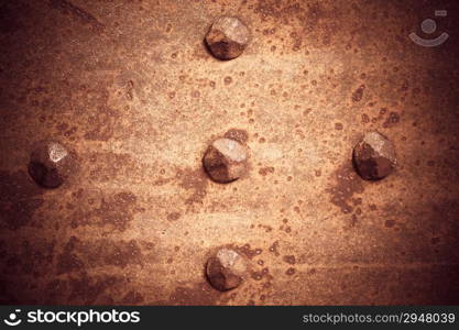 Brown grunge metal plate or armour texture with rivets as background