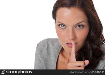 Brown hair woman with with finger on lips on white background