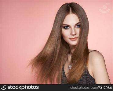 Brown-haired Girl with Long Healthy and Shiny Smooth Hair. Care and Beauty. Beautiful Model Woman Smiling. Make-Up and Jewelry
