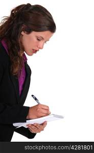 Brown-haired woman writing on a notepad