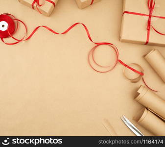 brown kraft paper, packed gift bags and tied with a red ribbon, set of items for making gifts. Package design, copy space