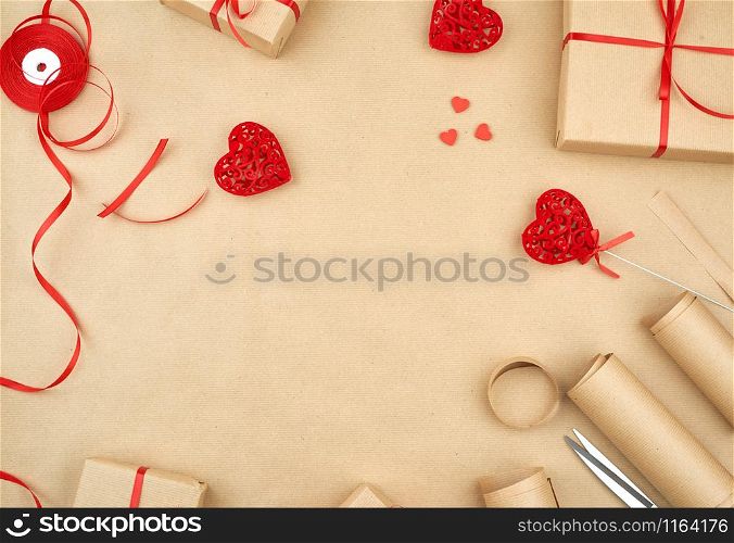 brown kraft paper, packed gift bags and tied with a red ribbon, red heart, set of items for making gifts. Gift wrapping. Package design, copy space