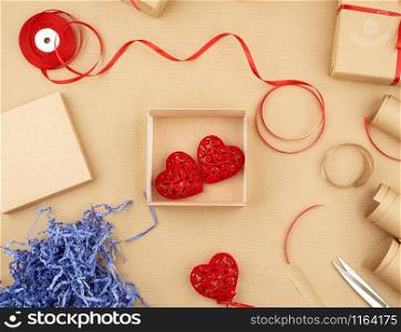 brown kraft paper, packed gift boxes and tied with a red ribbon, red heart, set of items for making gifts. Package design, top view