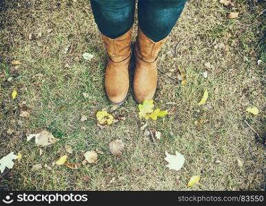 brown leather boots on female legs, top view, autumn day