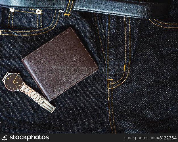 Brown leather wallet on jeans background.