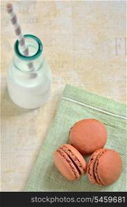 brown macaroons with milk and straw on the table