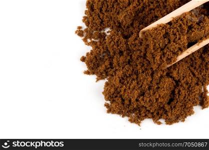 brown muscovado sugar in scoop isolated on white background