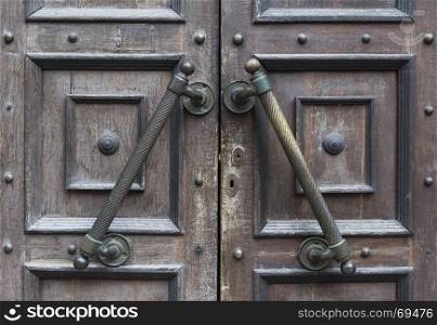 brown old entrance doors with large brass handles