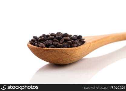 Brown organic lentils in wooden spoon isolated on white background