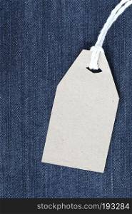 Brown paper label with hemp rope tied on denim or jeans for design marketing background.