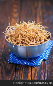 brown pasta in bowl and on a table