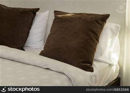 brown pillows on bed in bedroom