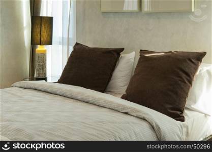 brown pillows on bed with lamp