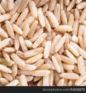 Brown rice scattered as a background. Food design.
