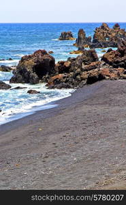 brown rock in white coast lanzarote spain beach stone water and summer hervideros