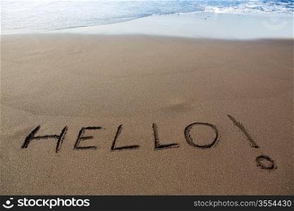 Brown sand beach with written word Hello in Canary Islands