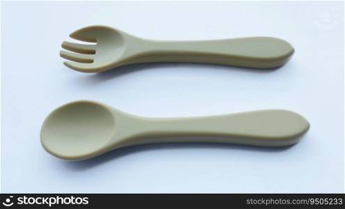 Brown silicone fork and spoon baby utensil isolated on white.