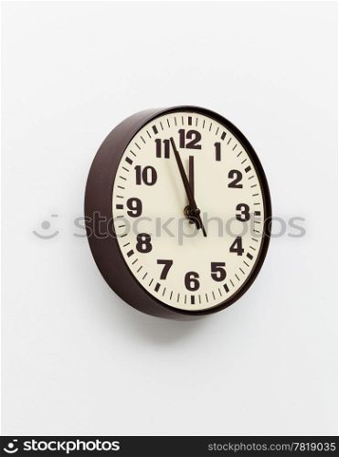 Brown simple plastic wall clock on the wall of office and concept of running out of time