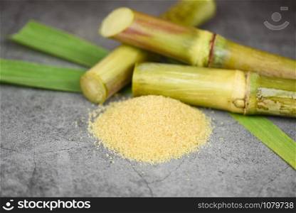 Brown sugar and sugar cane on gray table background
