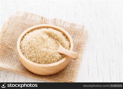 brown sugar and wood spoon in brown bowl on white wooden table