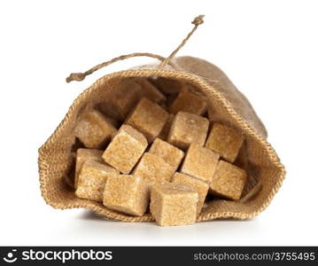 Brown sugar cubes in sack on white background. Macro shot