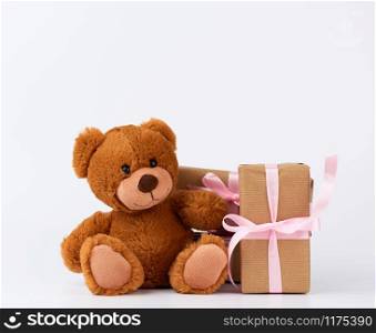 brown teddy bear, stack of gifts in boxes wrapped in brown paper, tied with silk ribbon, happy birthday and valentines da