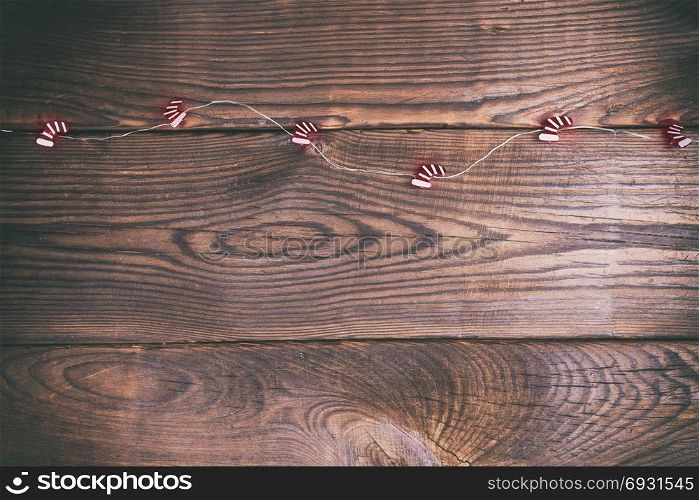 brown wood background and festive garland, empty space at the bottom