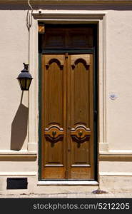 brown wood old door and a street lamp in the centre of colonia del sacramento uruguay