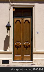 brown wood old door and a street lamp in the centre of colonia del sacramento uruguay