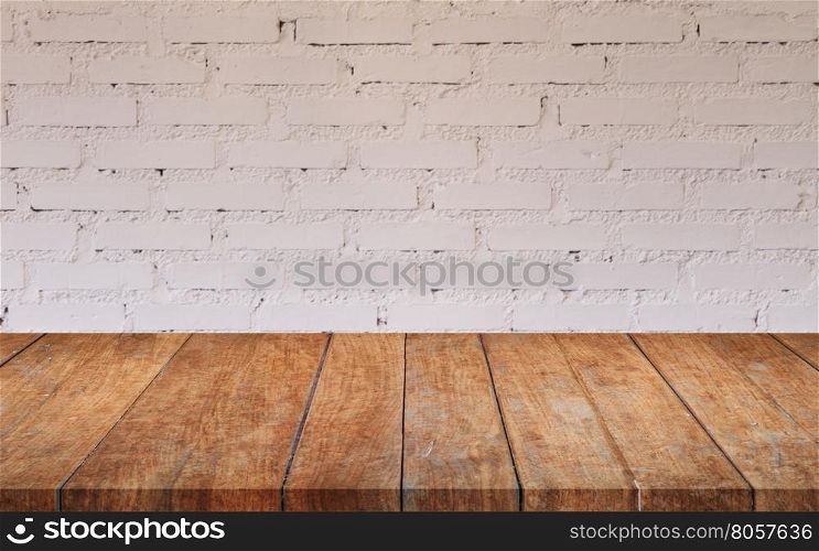 Brown wooden table top with white brick wall decorated in coffee shop