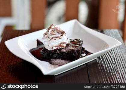 brownie cake served with chocolate sauce and whipped cream