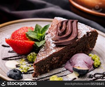 Brownie cake with a scoop of vanilla ice cream and strawberries