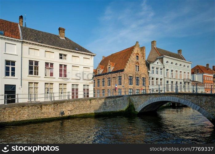 Bruges typical Belgian cityscape Europe tourism concept - canal and old Flemish houses and bridge. Brugge, Belgium. Brugge canal and old houses. Bruges, Belgium