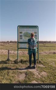 Bruinisse,Holland,27-feb-2019:woman looking for information on the information board at the slikken van heen in the netherlands,this is famous of the koniks horses and wet nature slikken. woman at information board in national park