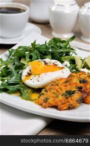 Brunch Idea. Egg poached with pumpkin spinach pancakes and garnish from arugula, avocado, mint leaves, and ricotta