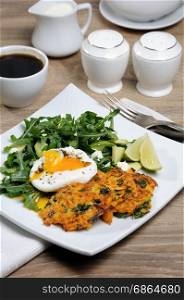 Brunch Idea. Egg poached with pumpkin spinach pancakes and garnish from arugula, avocado, mint leaves, and ricotta