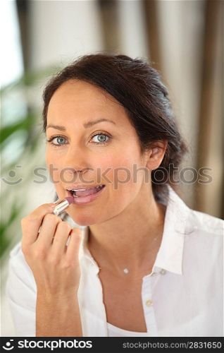Brunette applying lipstick
