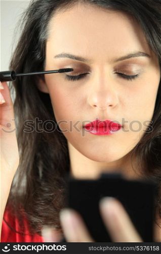 Brunette applying mascara