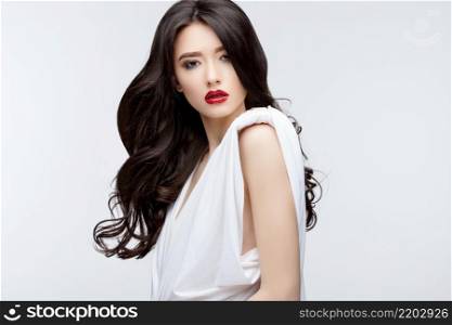 Brunette asian girl with long curly hair. Studio shot. Brunette asian girl with long curly hair